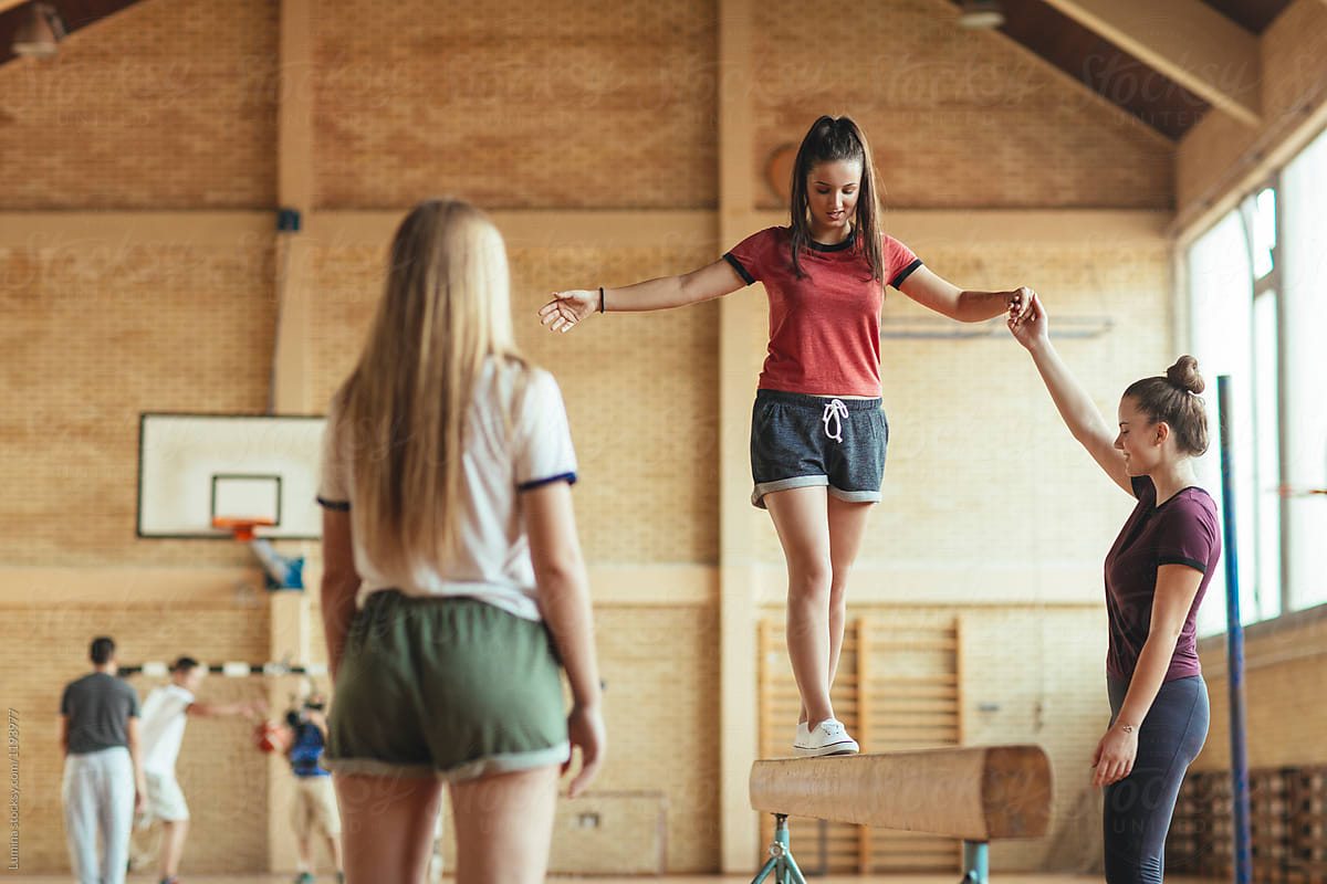 Girls Training Gymnastics At School Gym by Stocksy Contributor