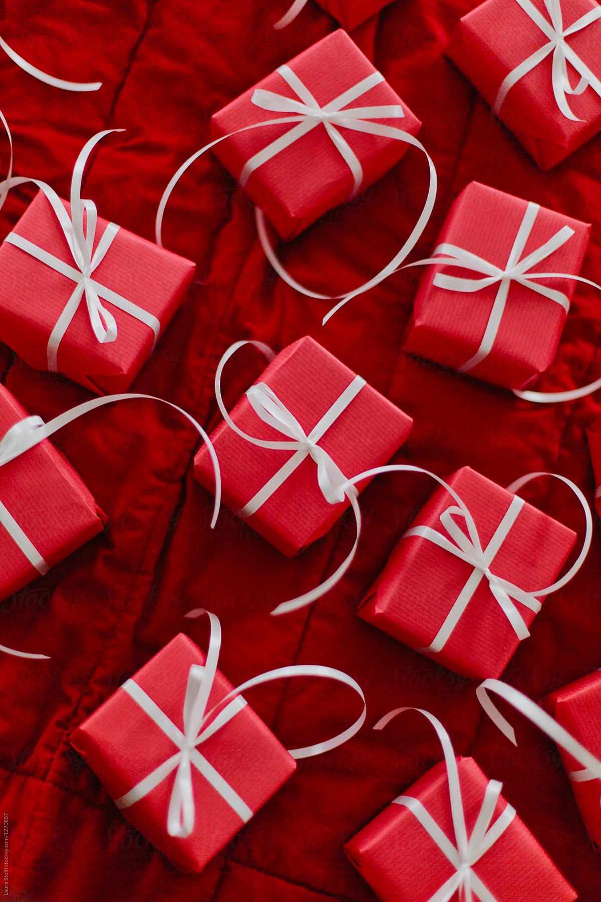 Many gifts in red boxes on bed