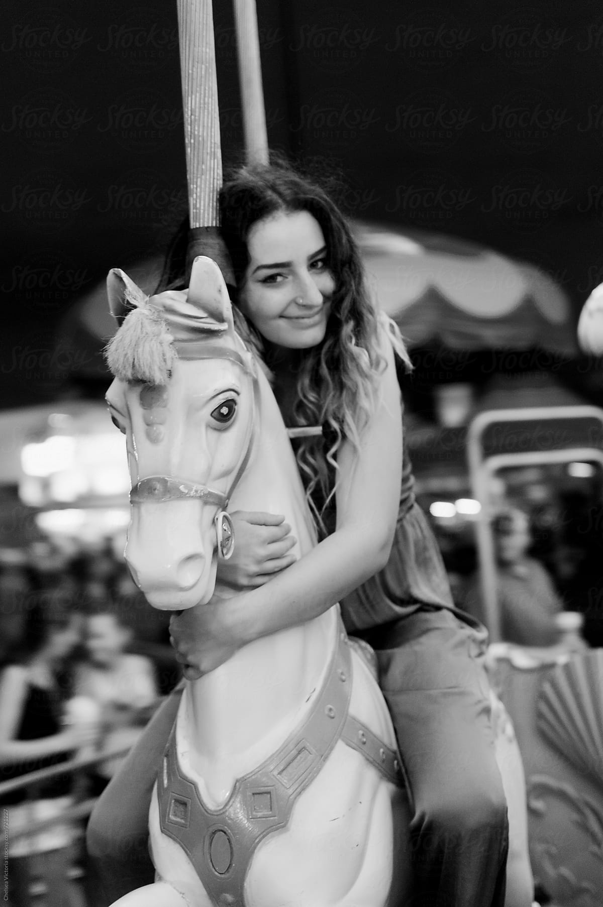 A young woman on a carousel at the carnival