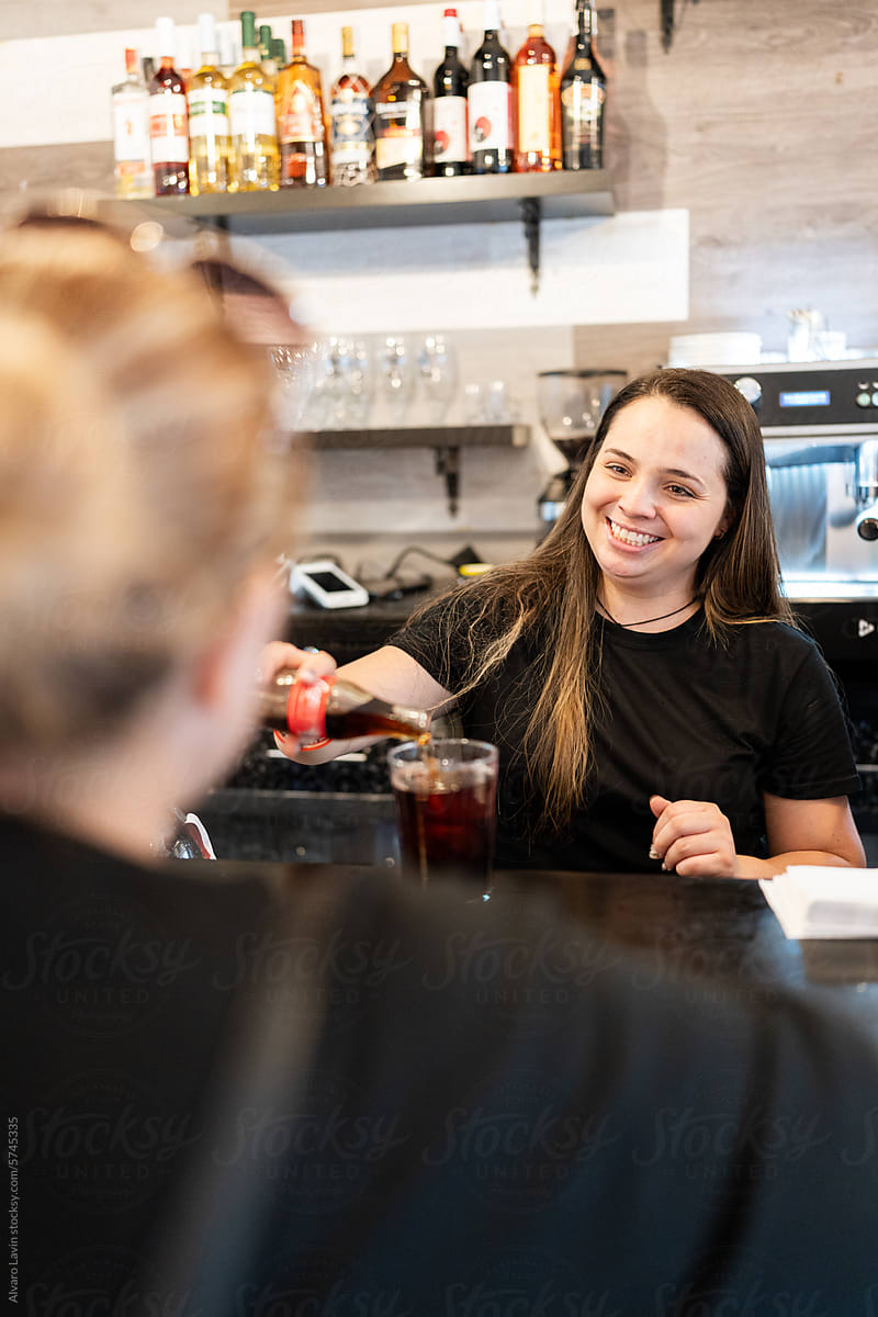 Waitress serving drink to client.