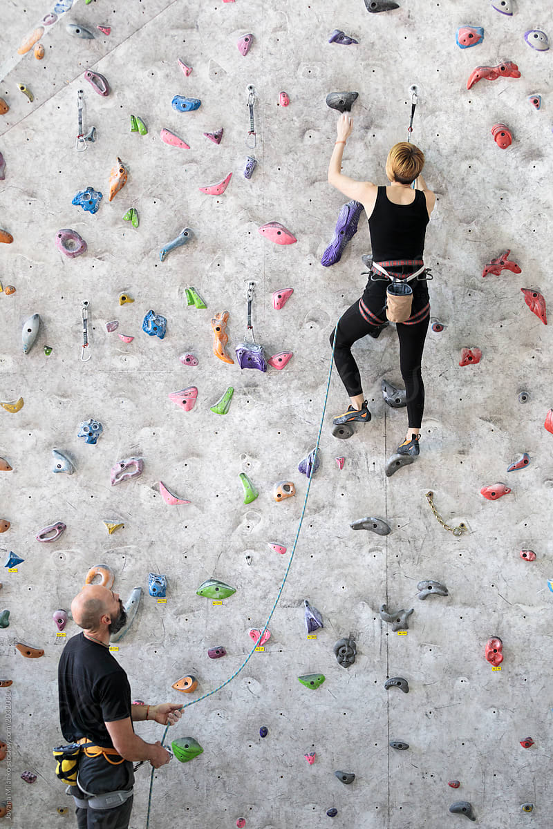 Husband and wife rock climbing in a gym