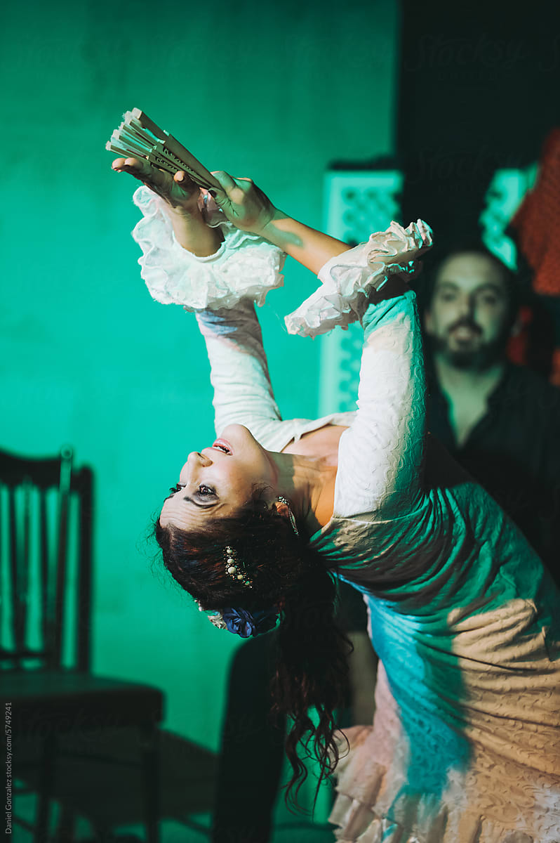 Female Spanish flamenco dancer bending backward on stage