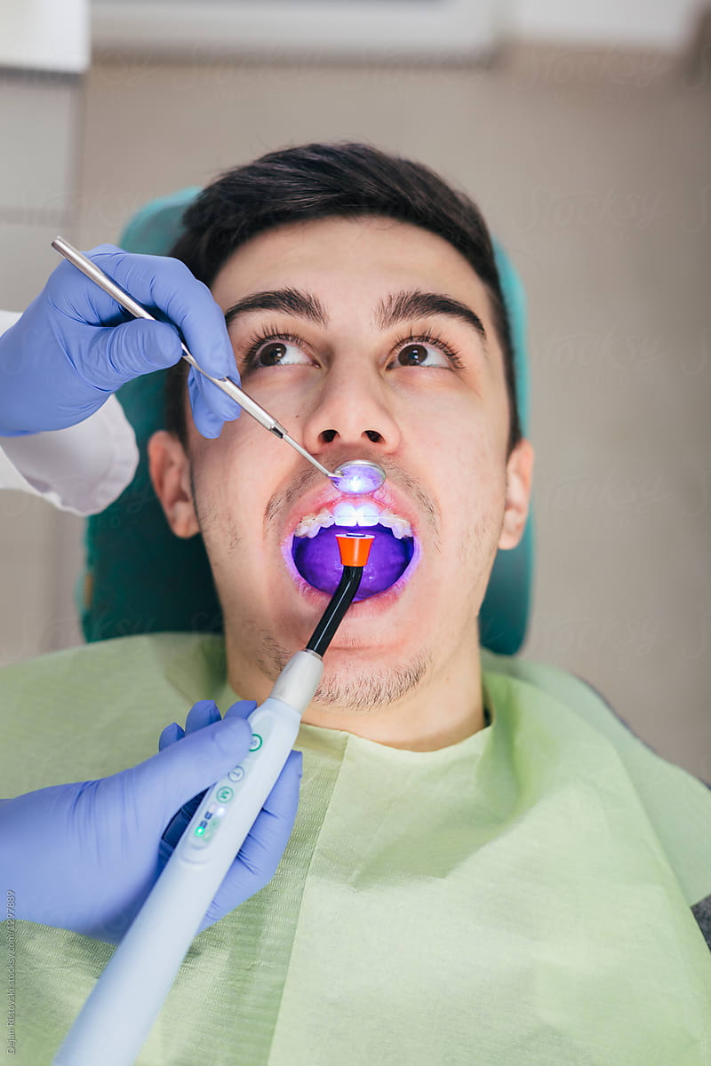 Teenager getting a filling on his teeth.