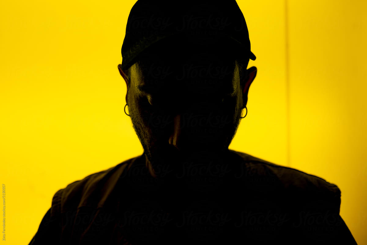 portrait of man in silhouette on a background of yellow lights.
