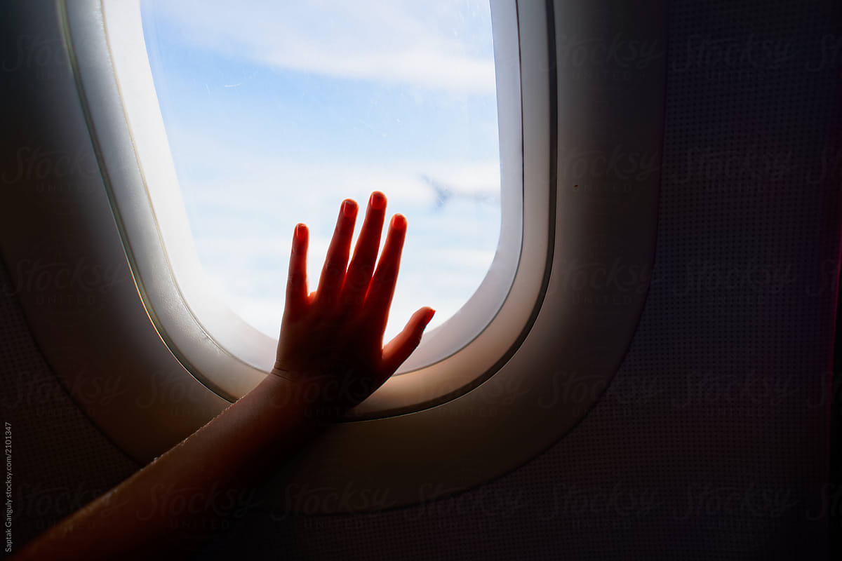 Little girls hand on an airplane window