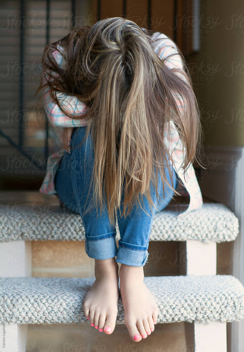 Teenage girl with long hair - head down hiding her face by 