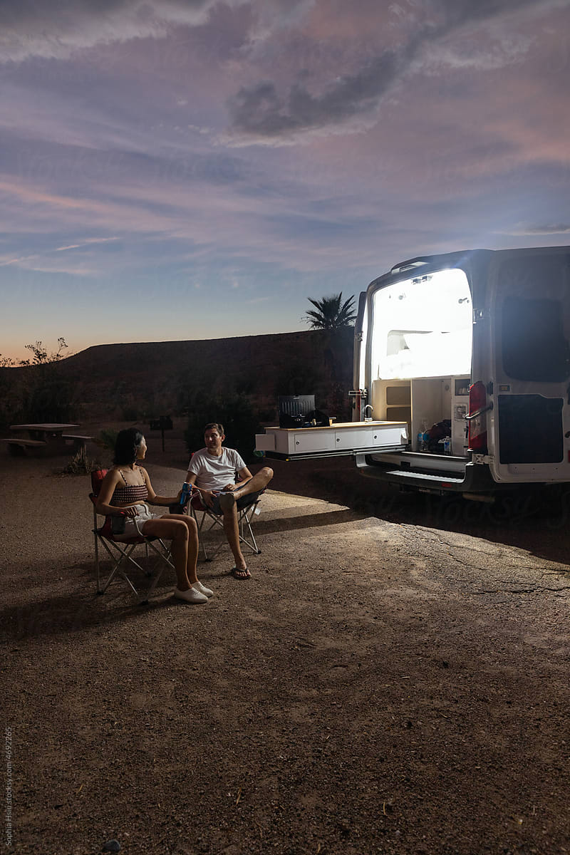 Couple sitting outside camper van