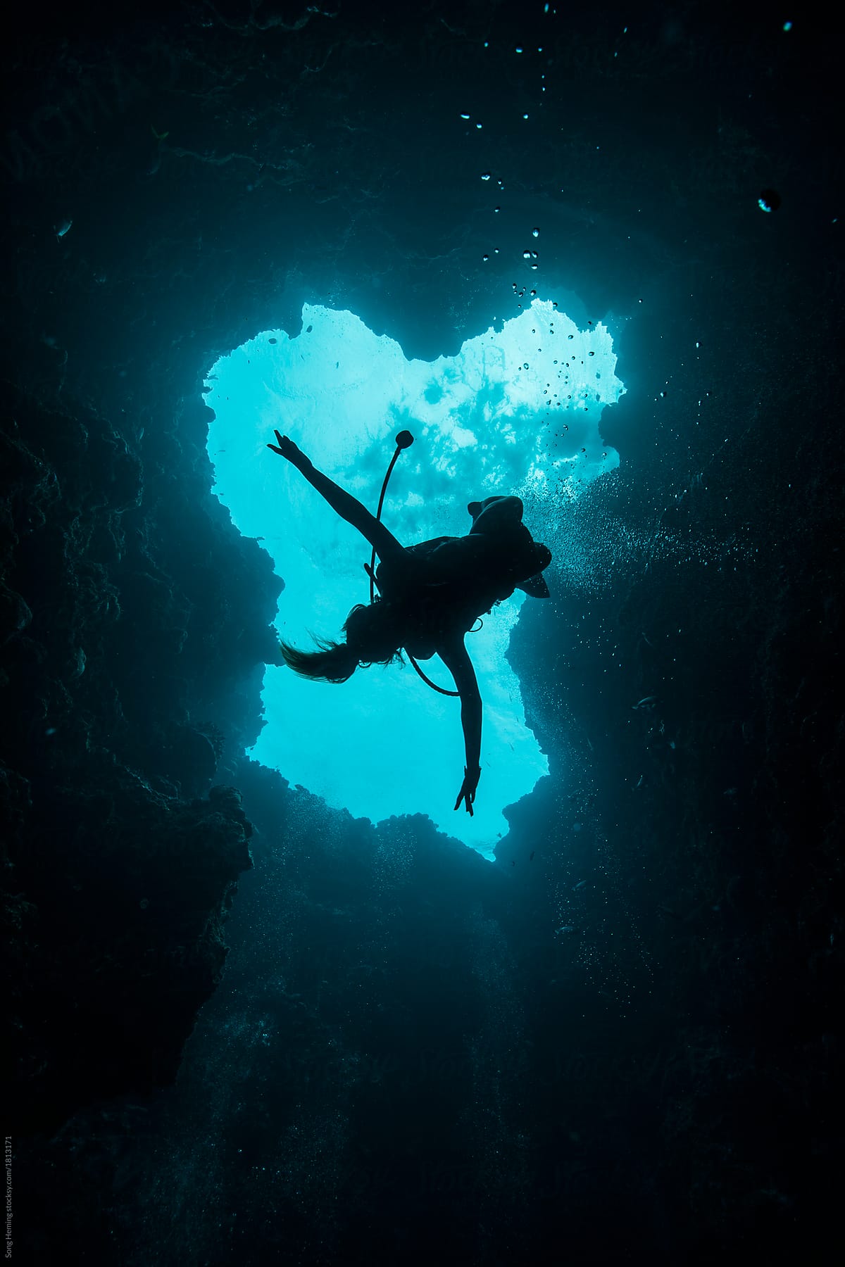 A young female scuba diver diving down to the blue hole
