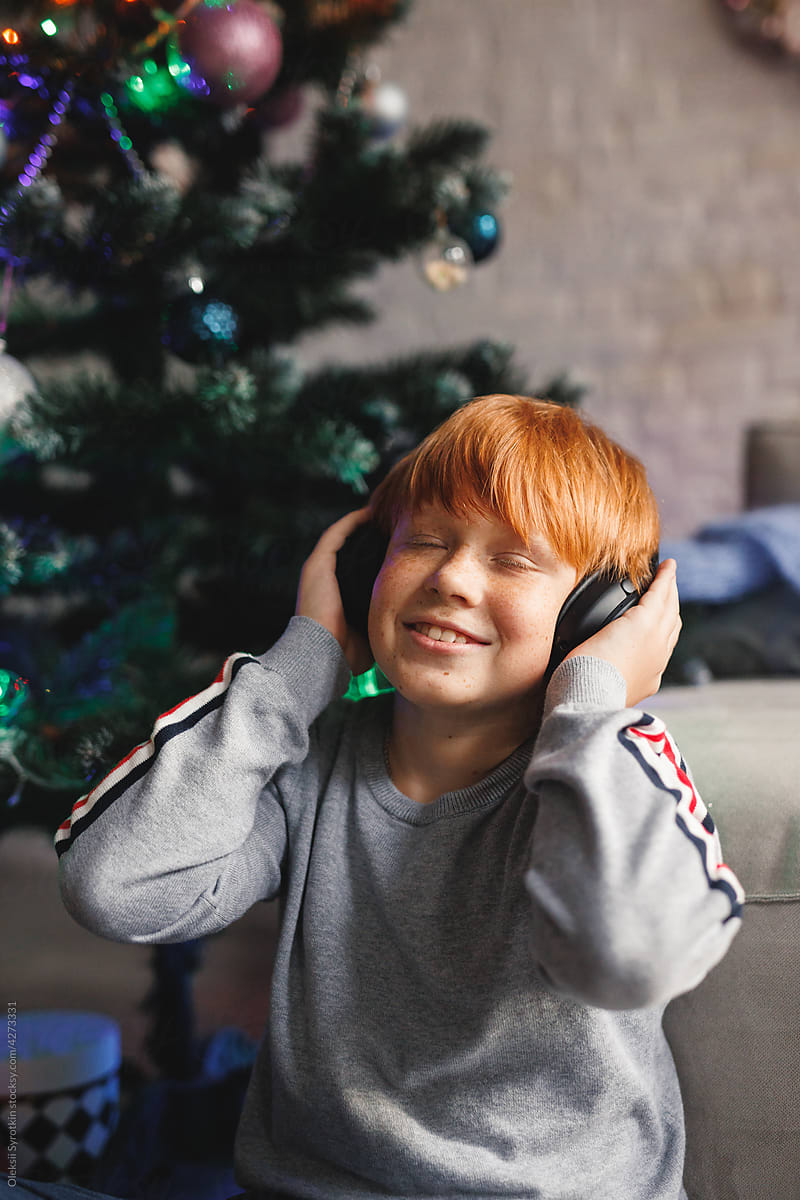 Little boy listening music and enjoying Xmas atmosphere