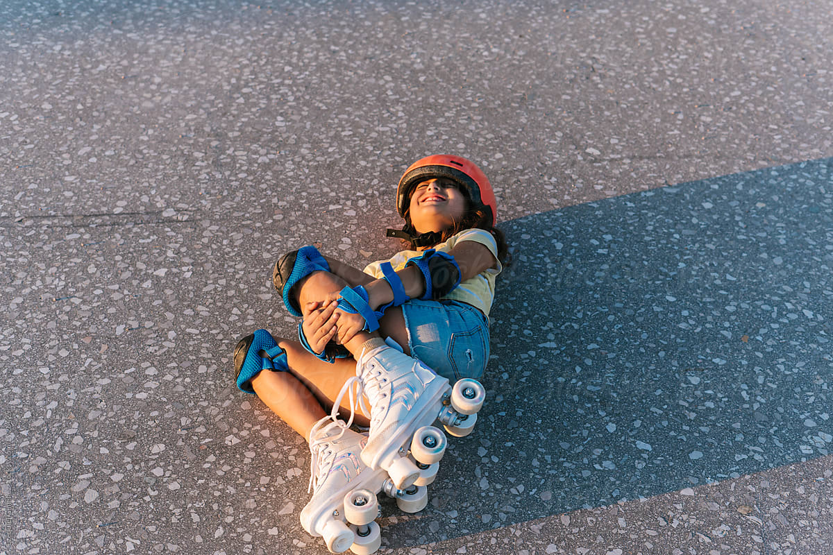 Girl in roller skates lying and crying after fall