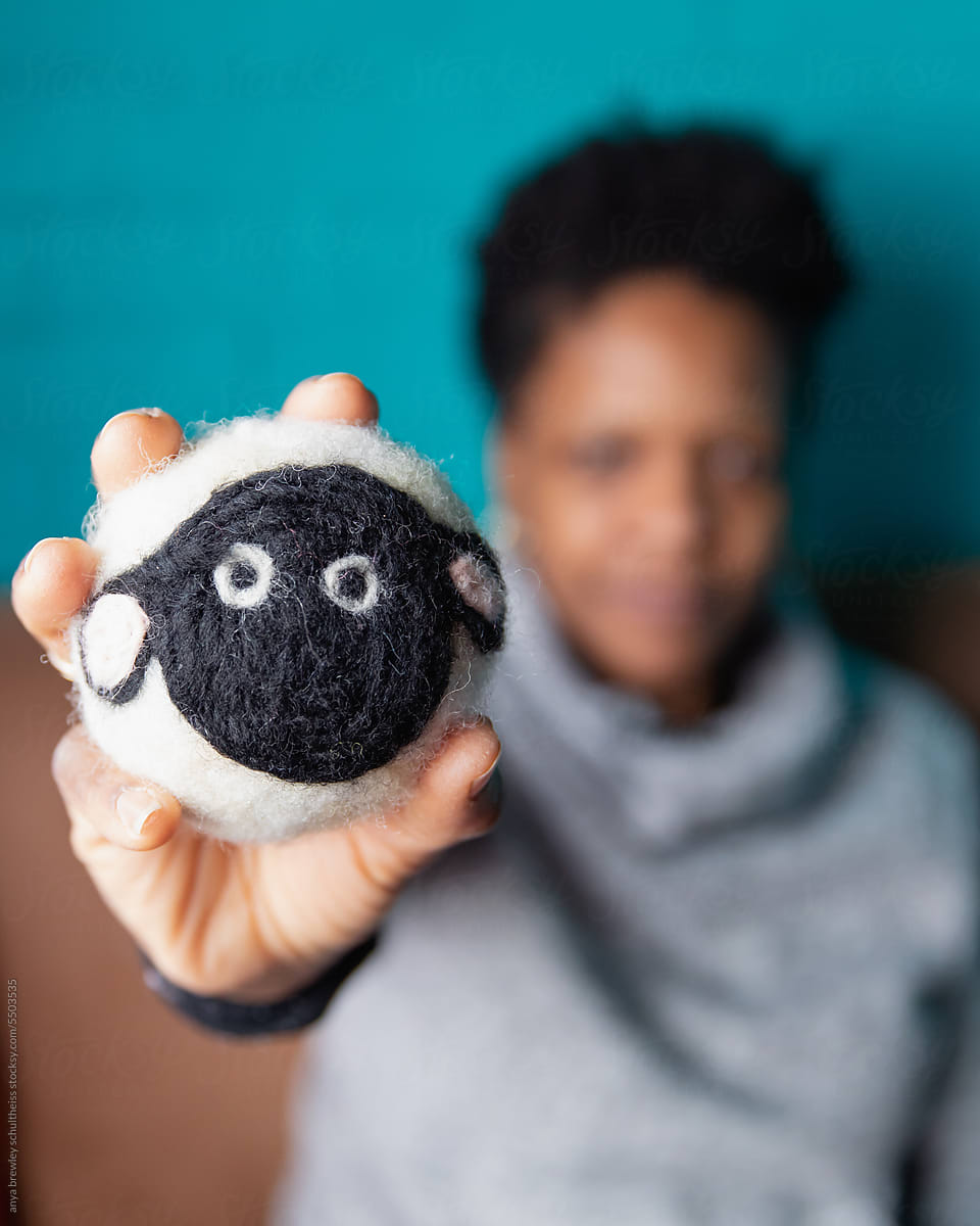 Woman holding a cute handmade sheep dryer ball