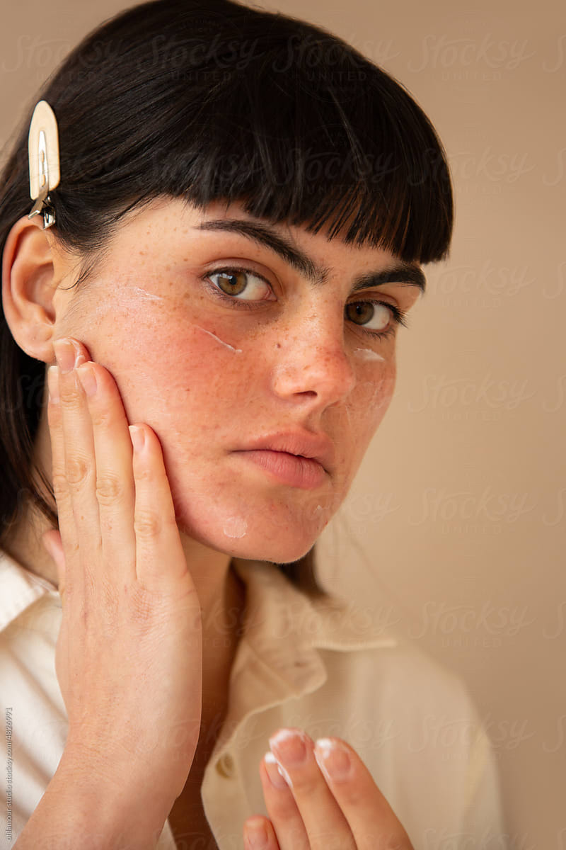 Woman using face lotion