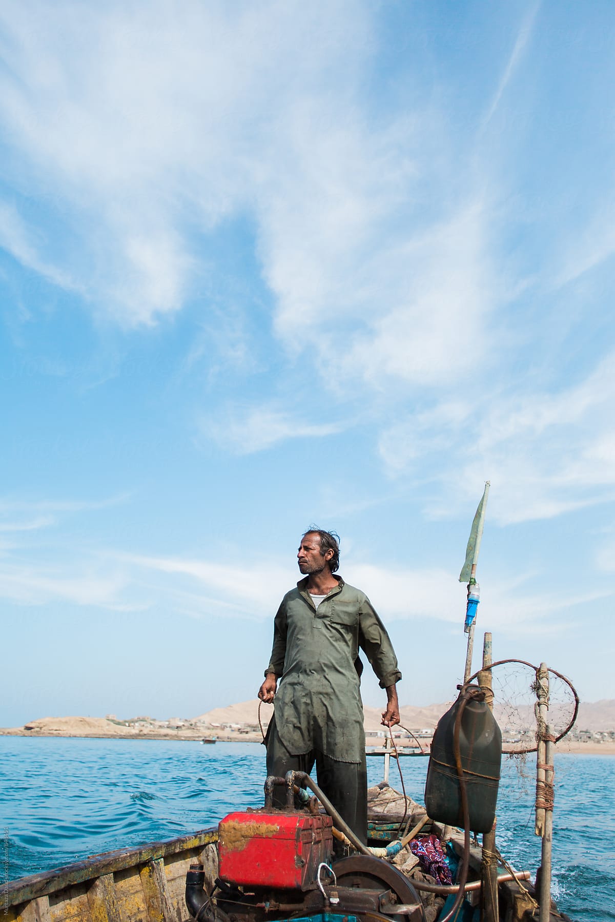 A fisherman and captain standing high on his boat