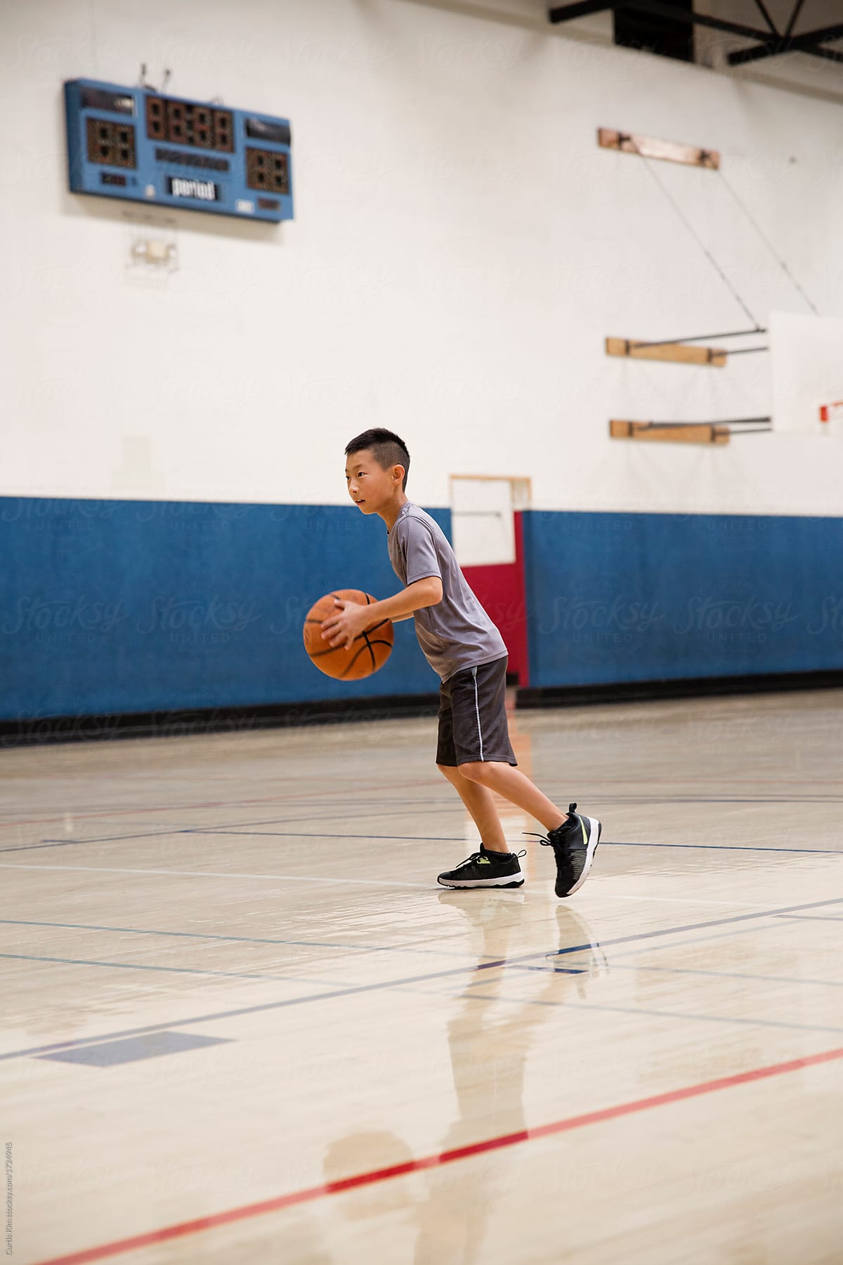 Boy playing basketball in an indoor gym