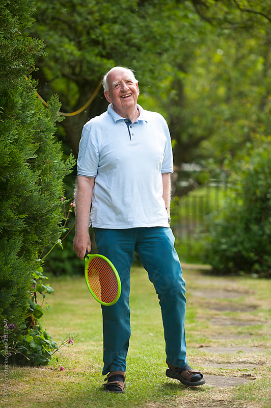 senior man holding a plastic tennis racket