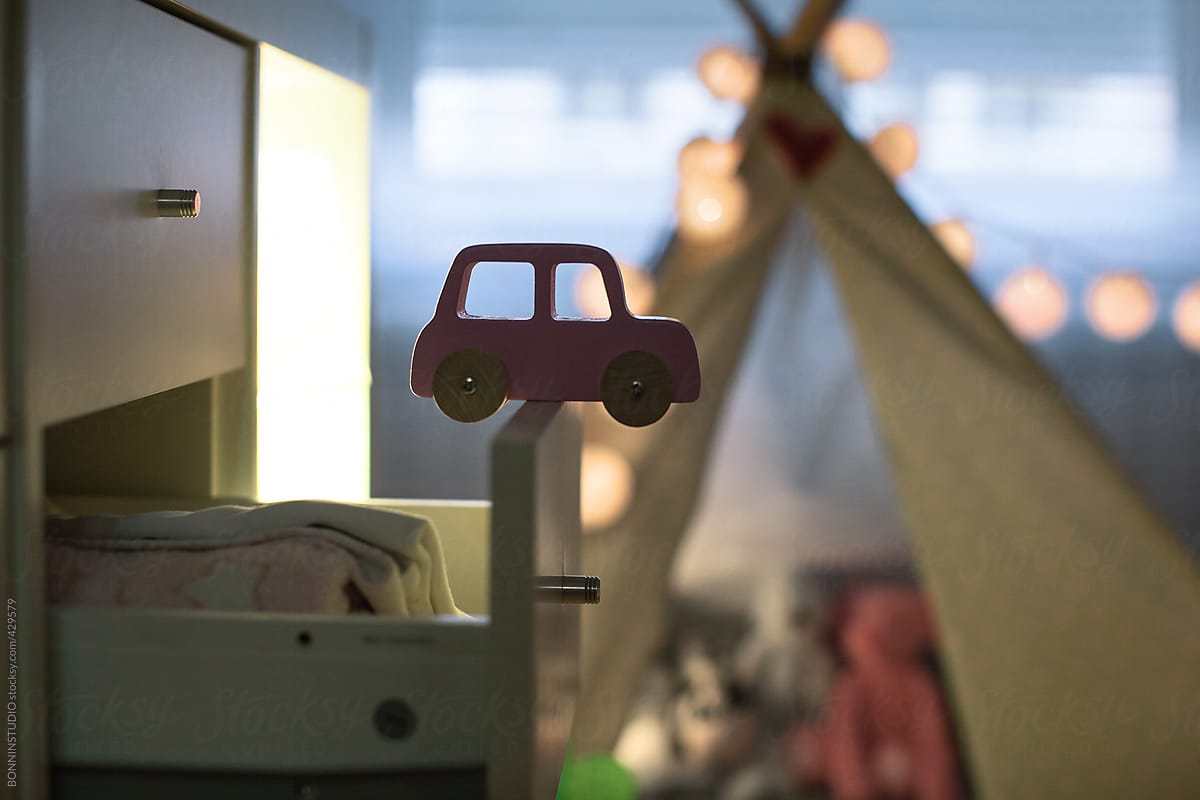Detail of pink toy car in a baby room.