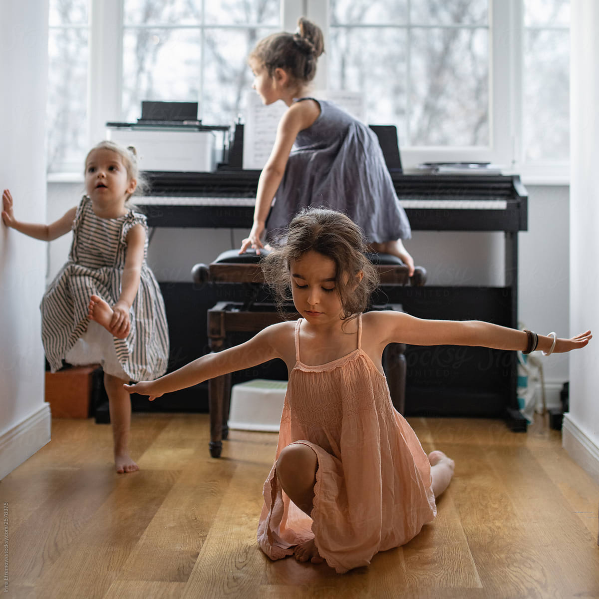 Three little girls goofing around the piano