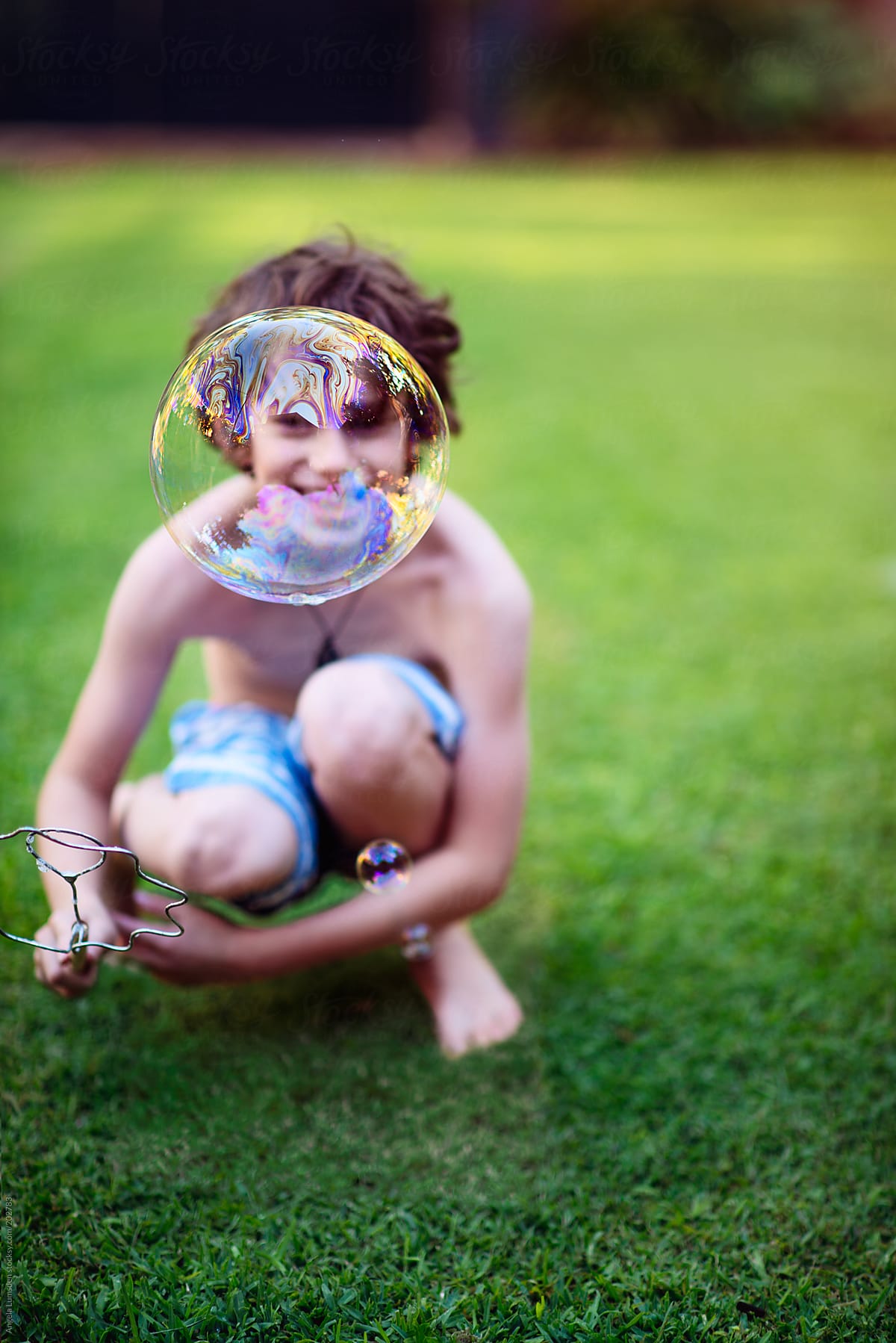 Boy playing with bubbles in a garden in summer