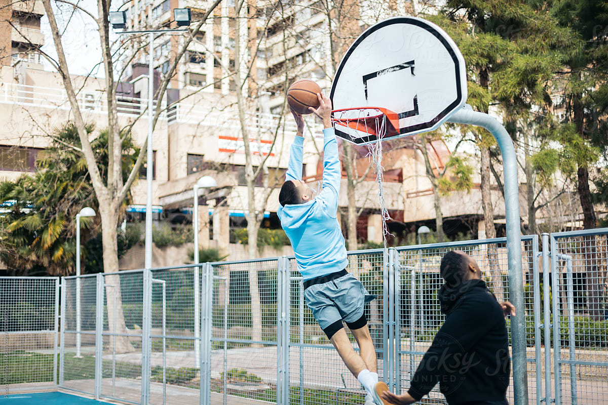 Young men playing street basketball
