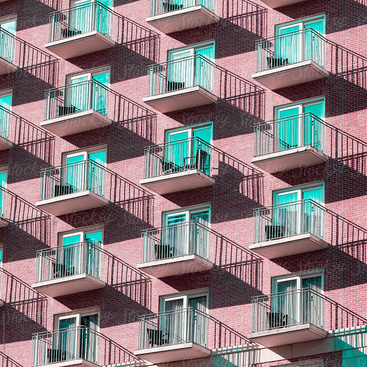 Pink building with blue windows and shades