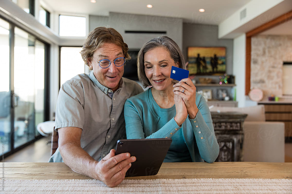 Retired Couple Prepares To Pay For Something On Their Tablet