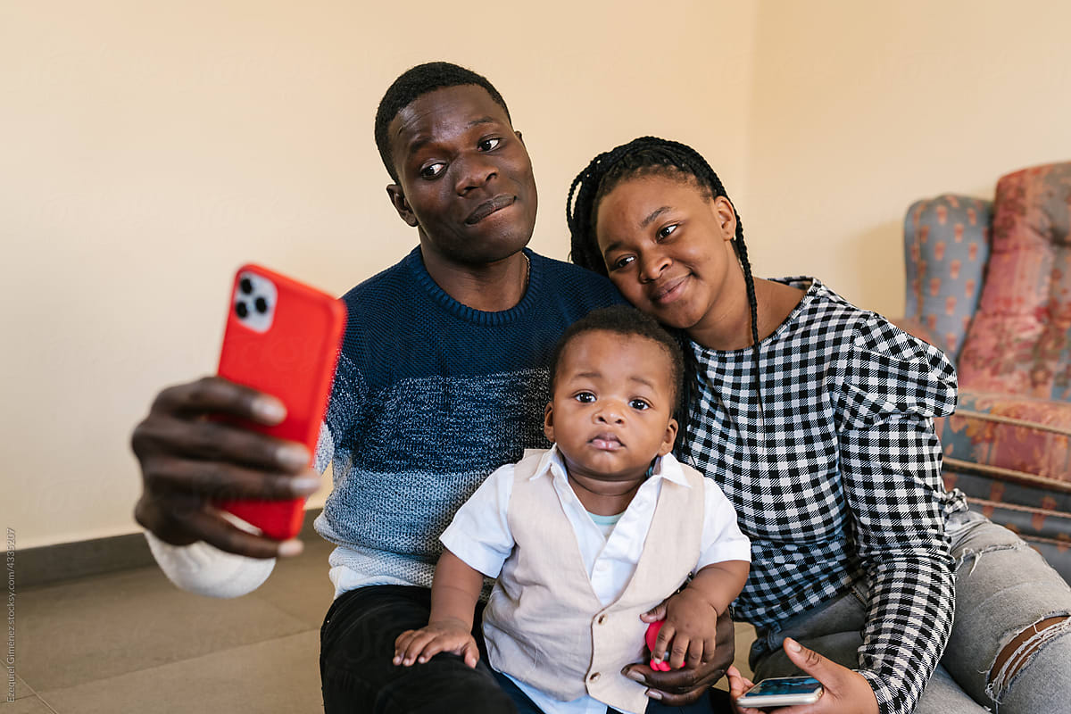 Loving gentle family taking selfie on smartphone