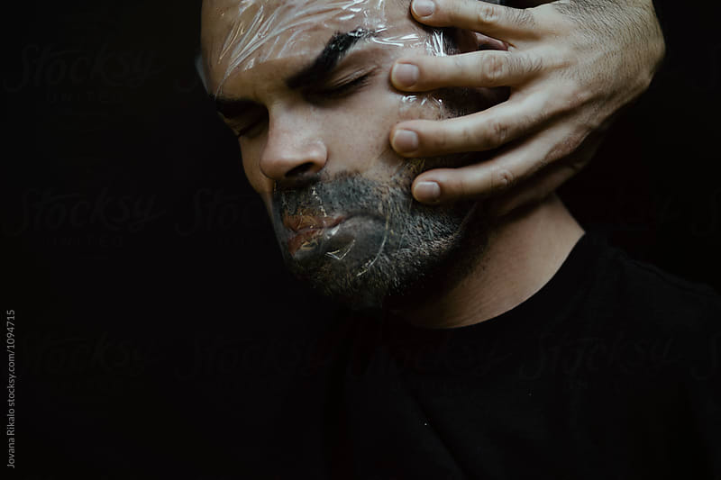 Artistic portrait of a man with face covered with tape