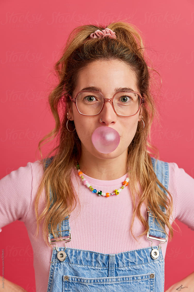 Teenage lady blowing bubble gum in studio
