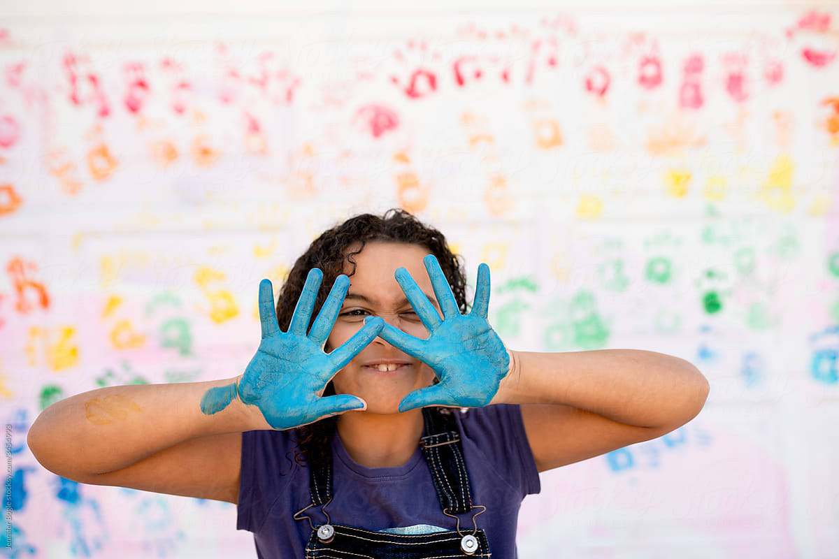 Girl holds up blue painted hands