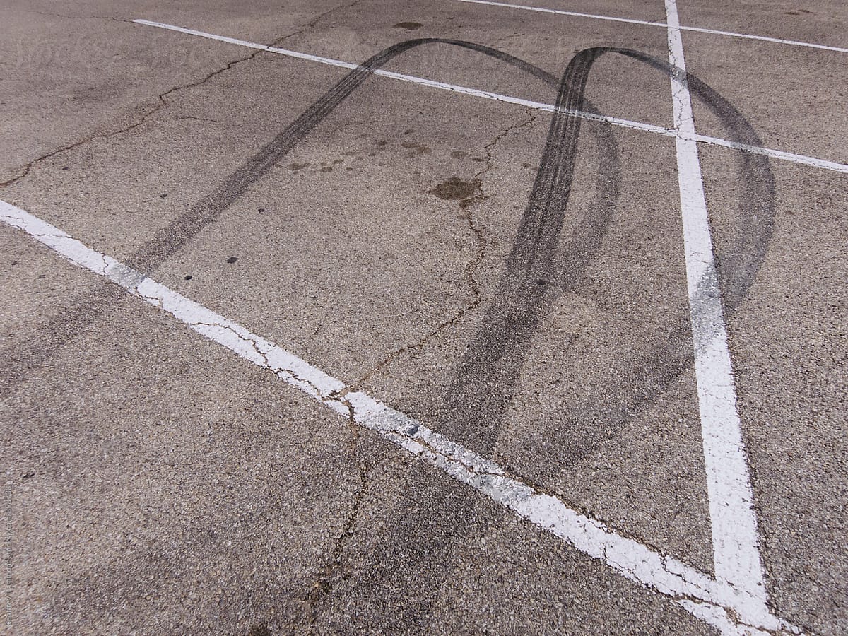 Skid Marks From Tires Peeling Out In Parking Lot by Stocksy Contributor  Geoffrey Hammond - Stocksy
