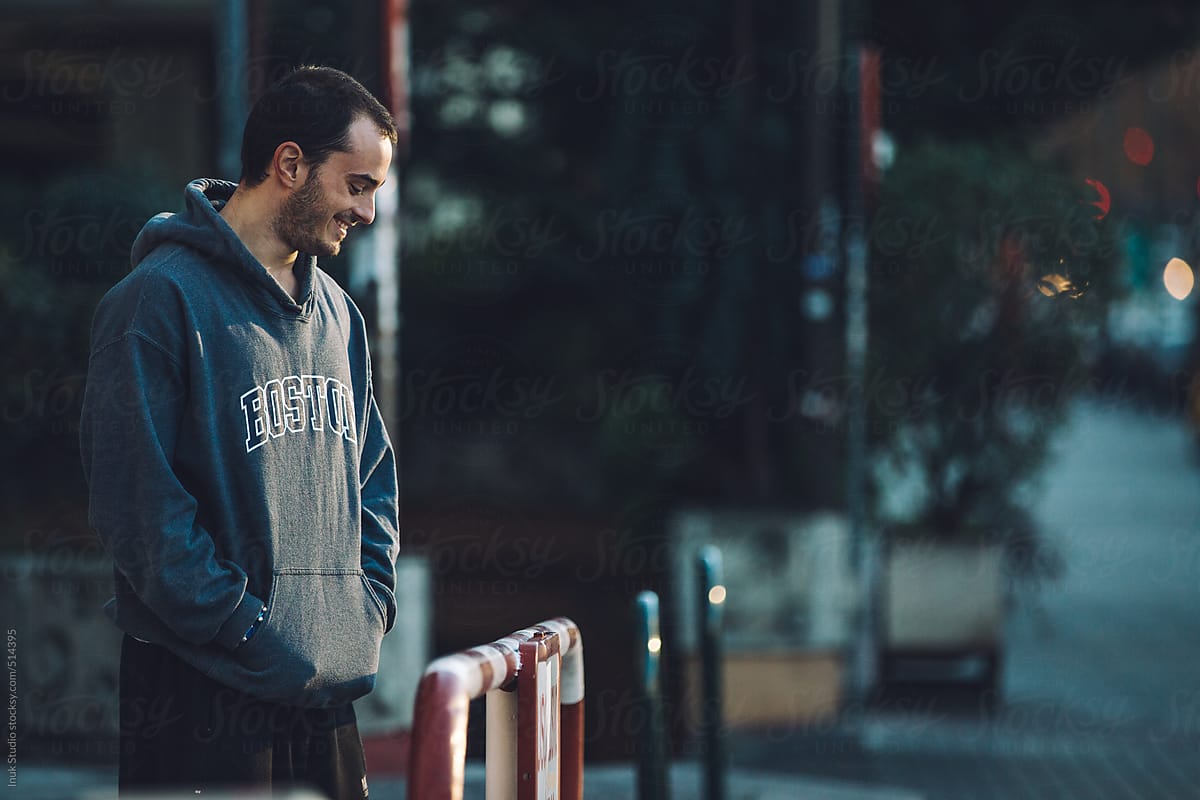 Man with a sweatshirt resting and laughing during a parkour training