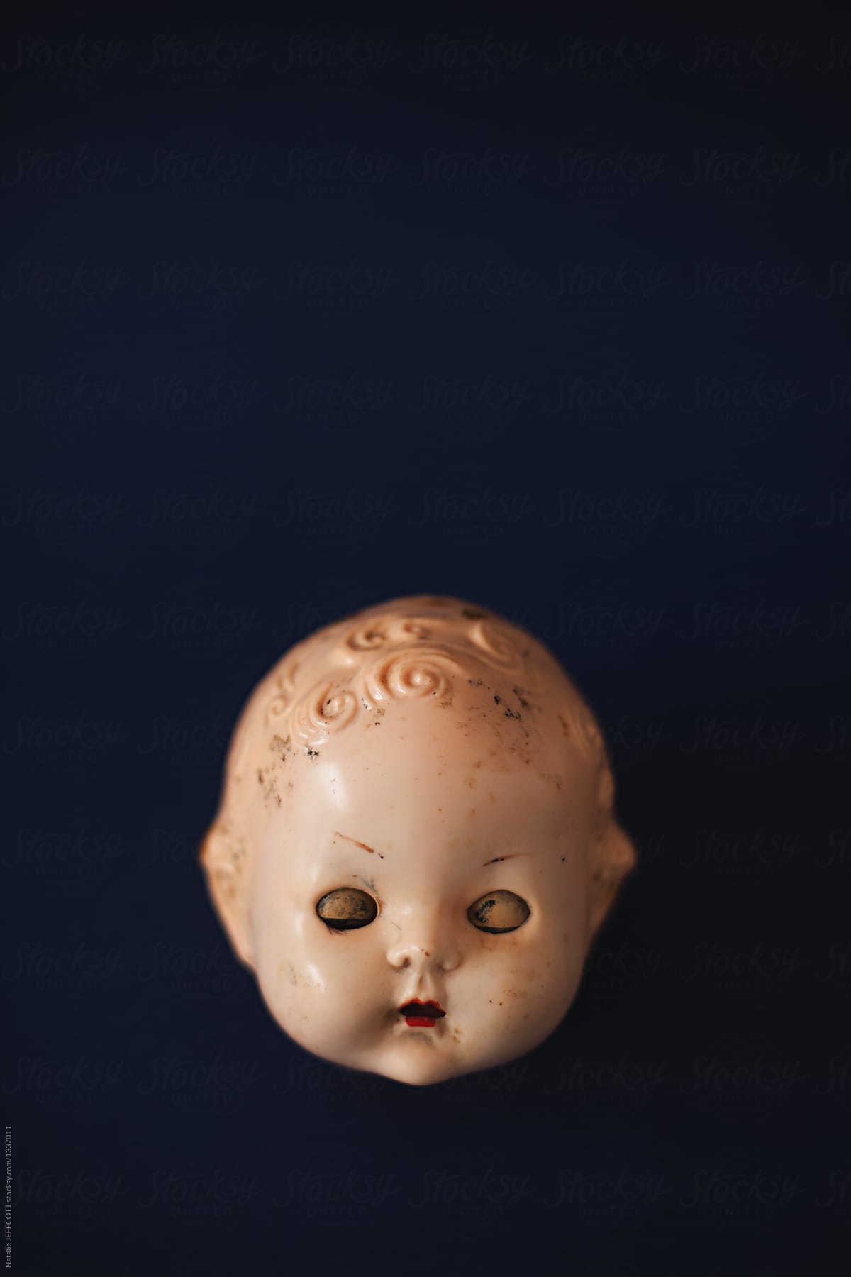 creepy dolls head with eyes closed with copy space
