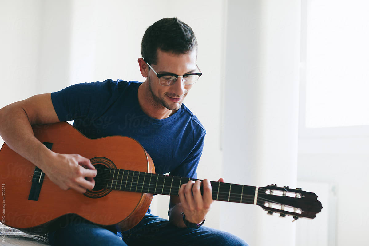 A Mature Adult Man Playing A Guitar, Side View Stock Photo