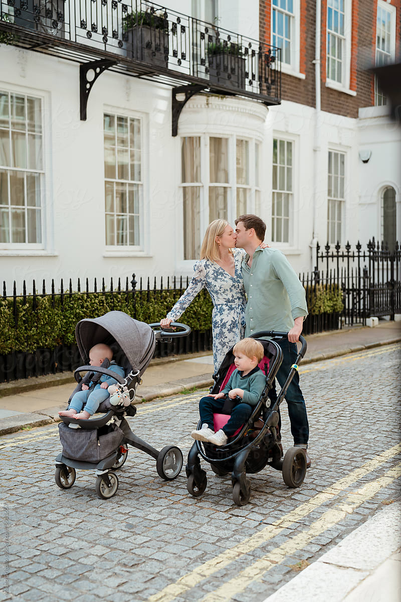 Couple with strollers taking their two children for a walk