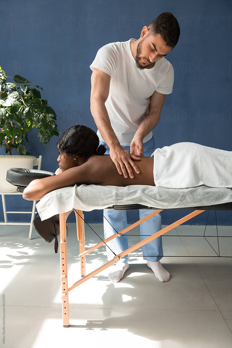 Man massaging back of black woman