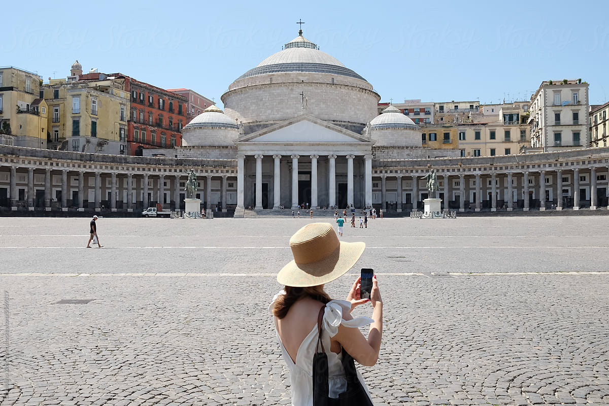 Portrait of an anonymous female tourist holding mobile phone in Naples