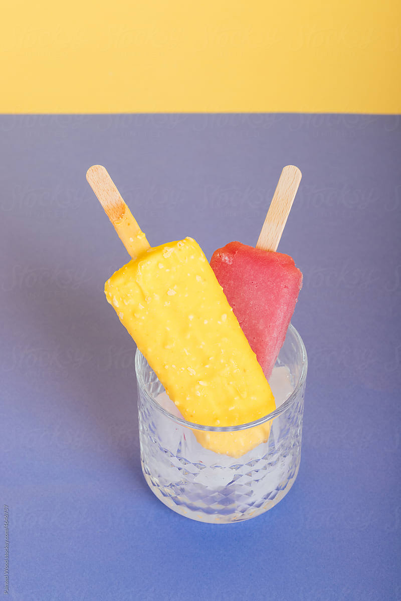Two popsicles in a glass full of ice