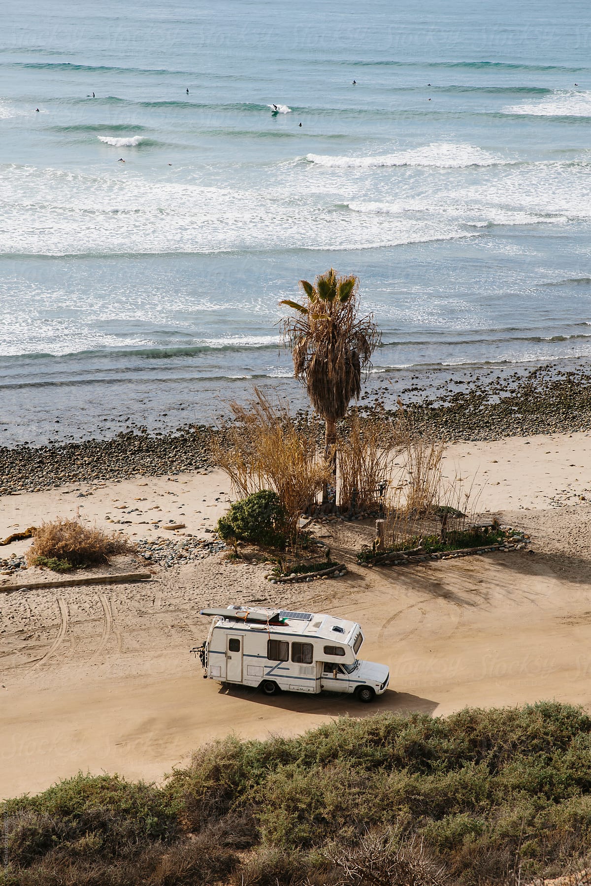 RV camper parked surrounded by nature and ocean