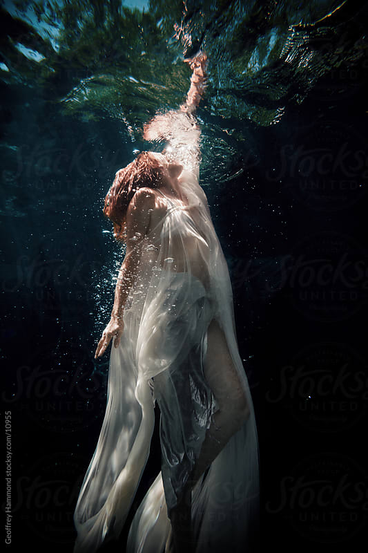 Woman Underwater Reaching to the Surface by Geoffrey Hammond - Stocksy