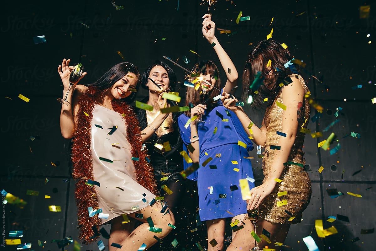 Four female dancing in confetti