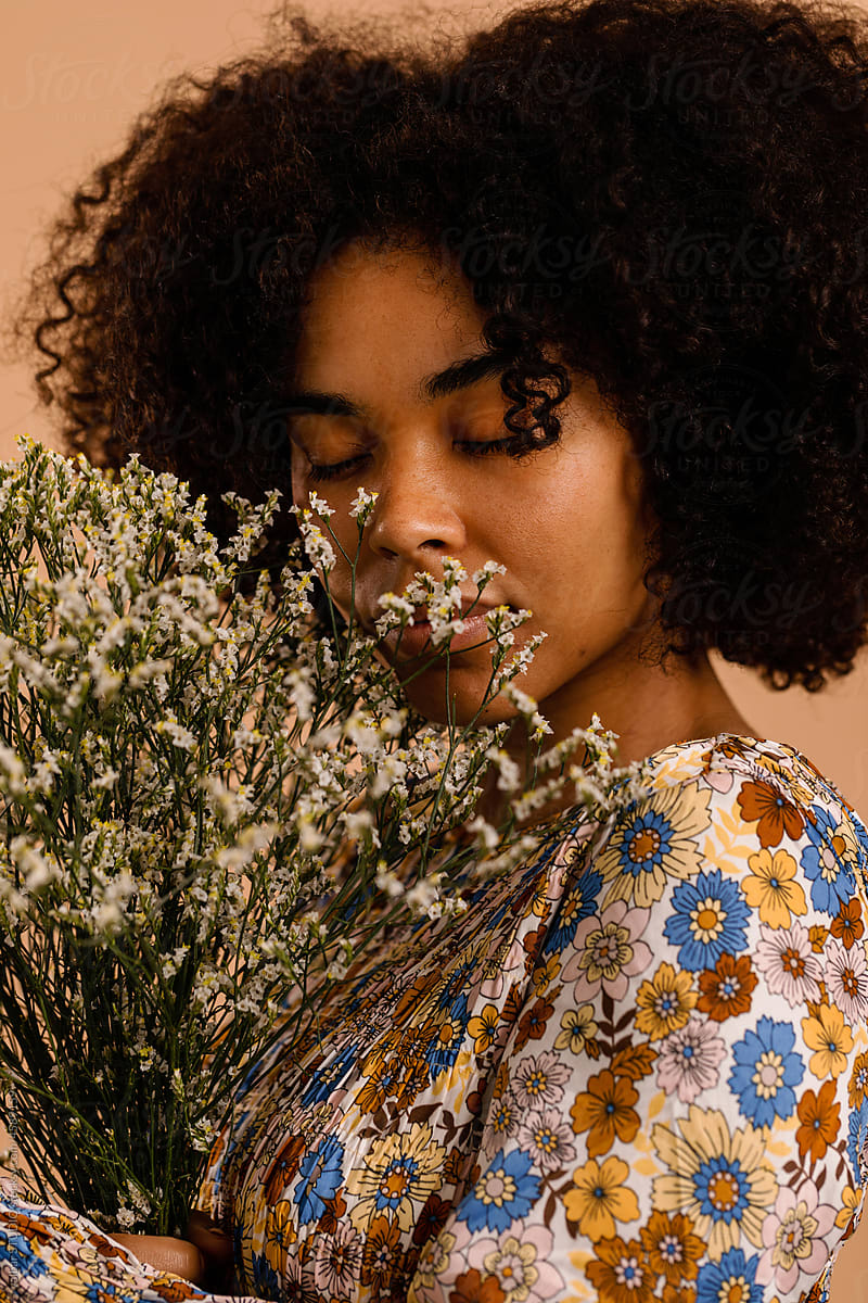 Serene woman with flower arrangement studio portrait