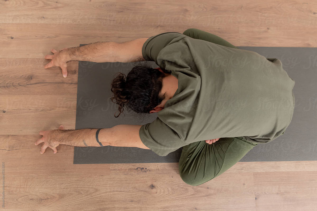 Anonymous man stretching body during yoga session