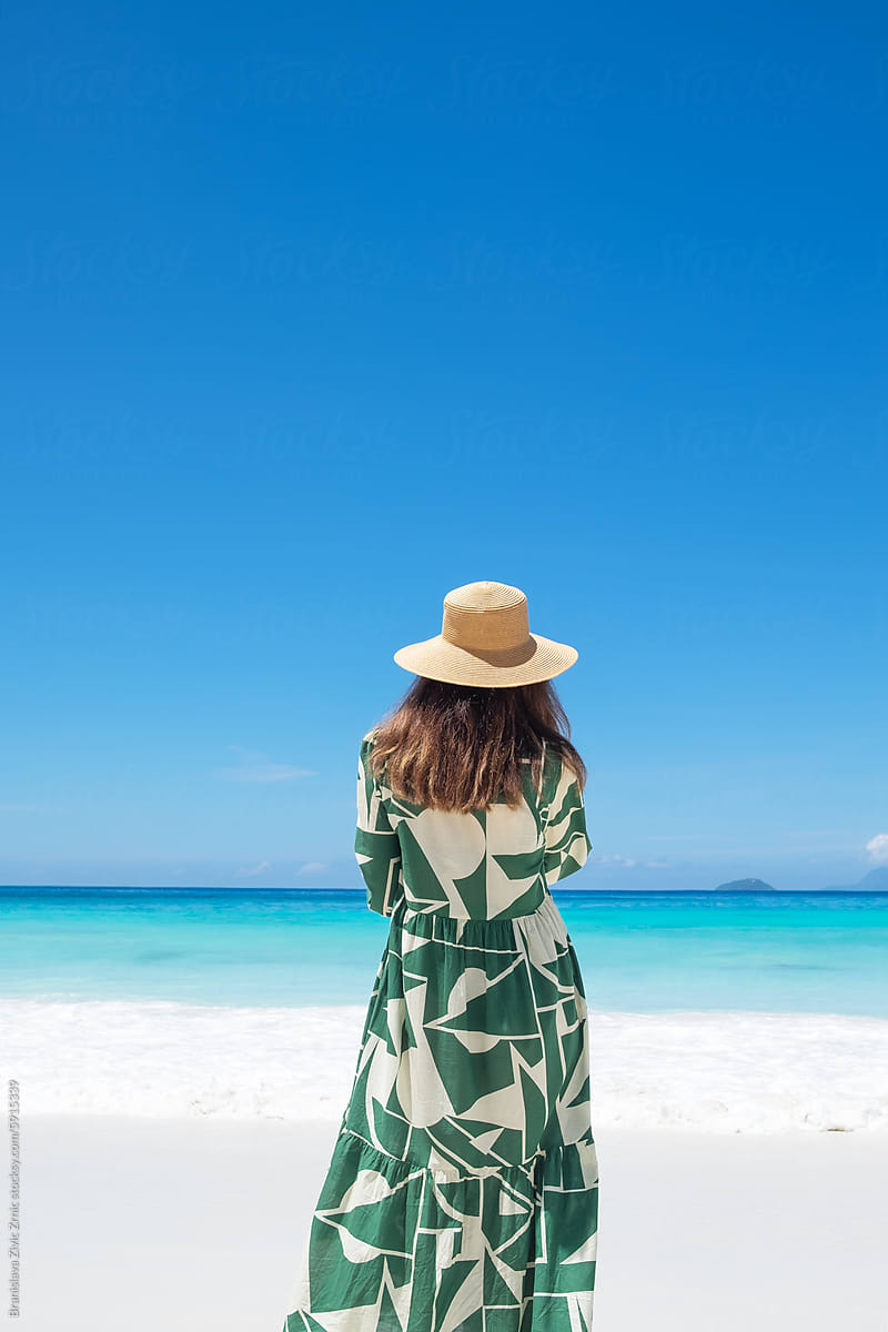 Anonymous female with a hat on the beach