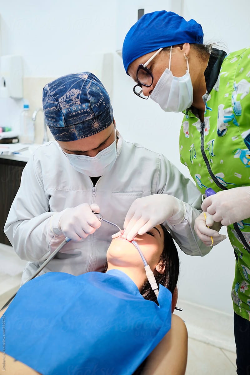 Two dentists performing a dental cleaning
