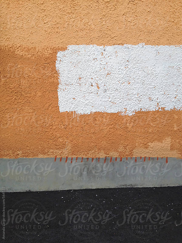 orange and white paint on a stucco wall