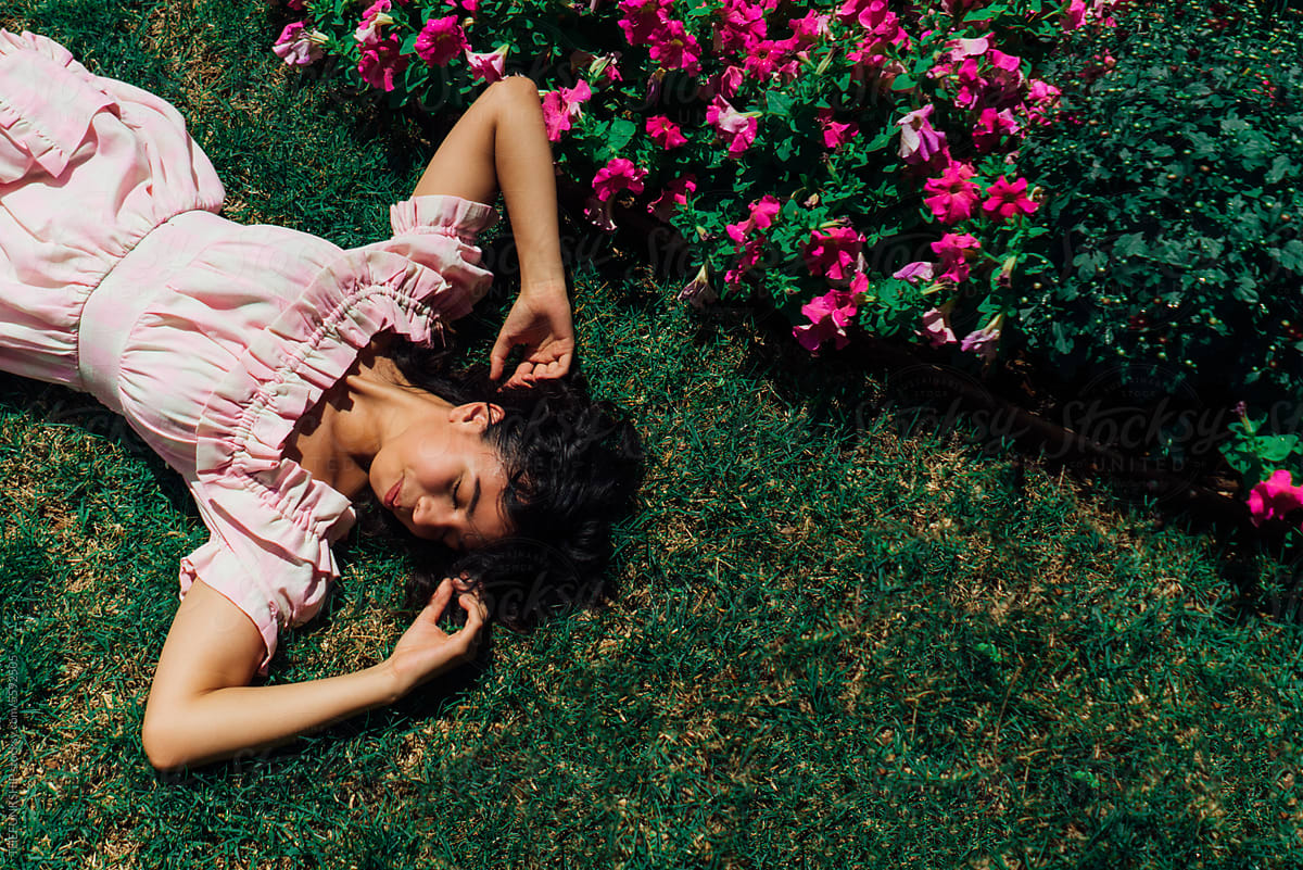 Girl In Pink Dress In Green Grass with Red Flowers