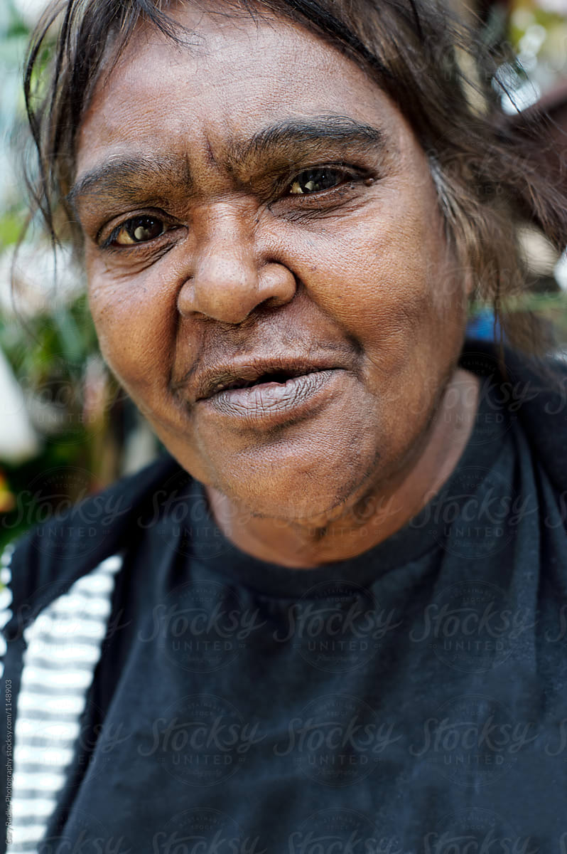 Aboriginal Woman Looking At Camera On A Blurred Background By Stocksy
