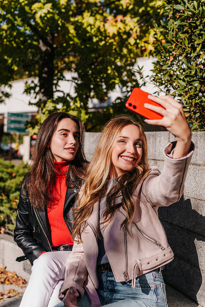 Portrait of young and cheerful friends taking a selfie on a sunny day