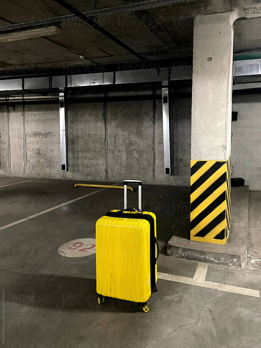 Yellow suitcase in the parking lot