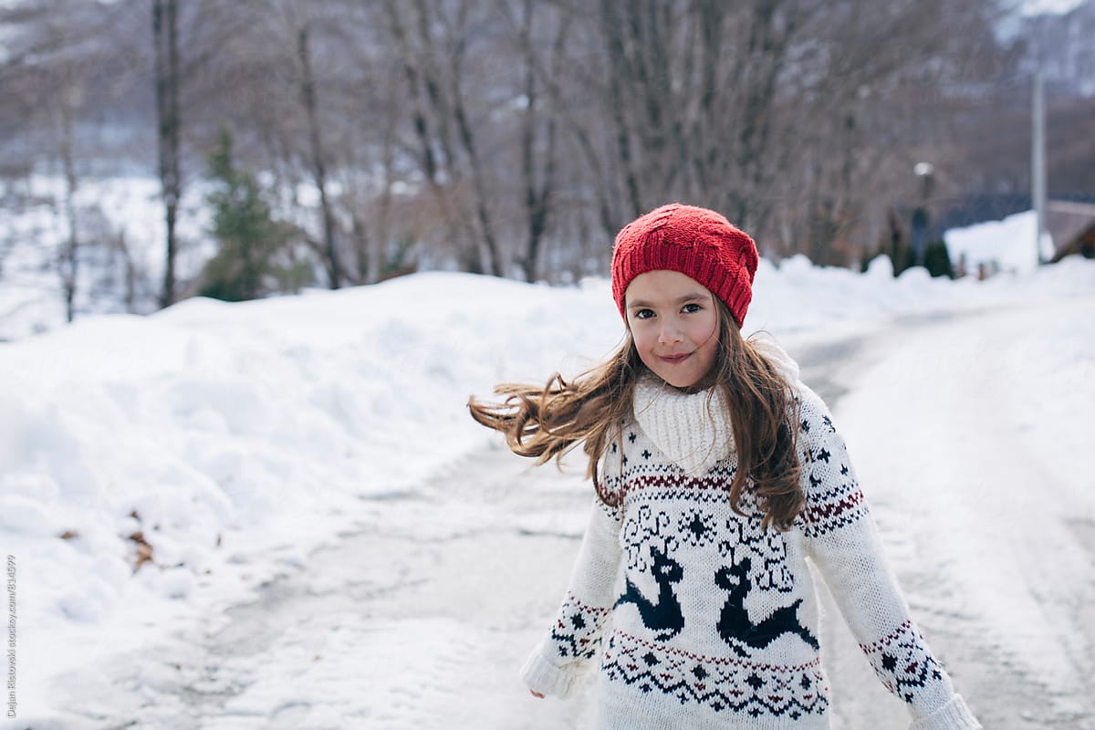 Girl playing on snow by Dejan Ristovski - Stocksy United